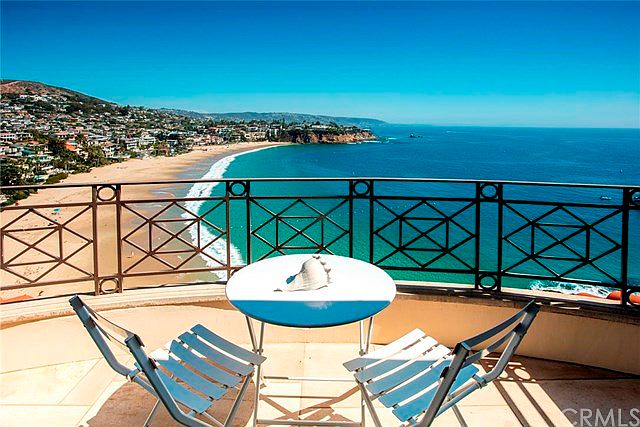 A balcony chair facing the cove, cliff and beach in view