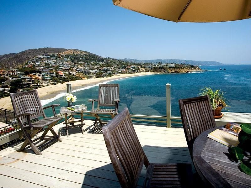 The terrace, deck chairs, and the whole arc of the bay below